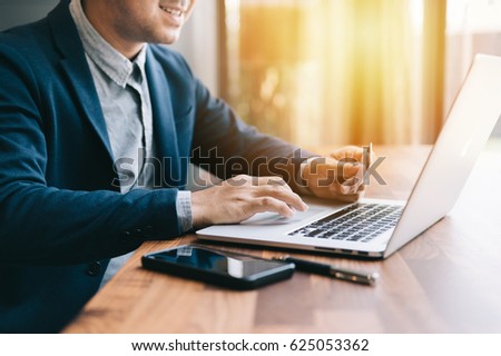 shopping online concept , businessman shopping online with computer laptop and credit card on vintage tone