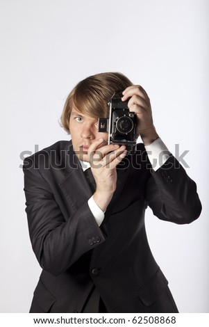 Handsome photographer in studio, ready to use his old film camera. See more in my portfolio