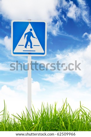 Traffic sign on green grass and blue sky.