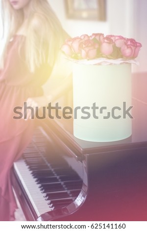 Light up and blurry girl with roses on piano