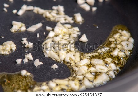 Chopped garlic cooking in hot olive oil