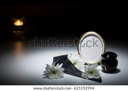 black urn with black tape,white chrysanthemum, candle
