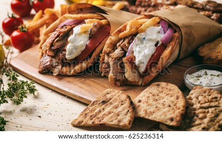Greek souvlaki, gyros wrapped in pita breads on a wooden background Royalty-Free Stock Photo #625236314