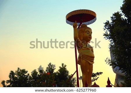 Golden Buddha statue with blue sky at twilight.