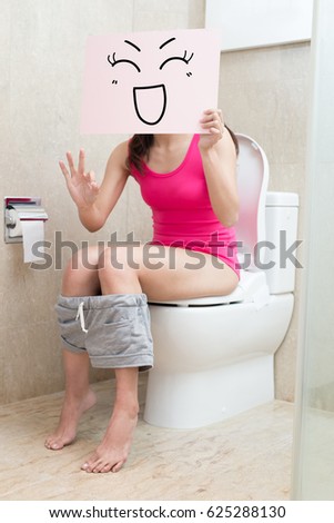 woman take smile billboard and show ok to you in the bathroom