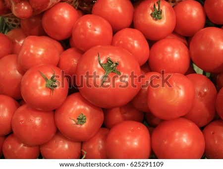 Heap of Vibrant Red Ripe Tomatoes with Green Stems 