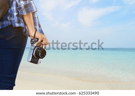 Women holding a camera and sea background, concept travel in summer