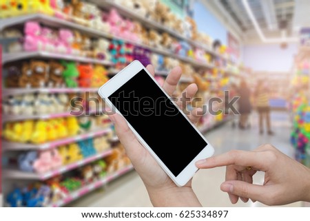 woman hand holding and using smart phone over blurred image of supermarket,shopping online by mobile concept