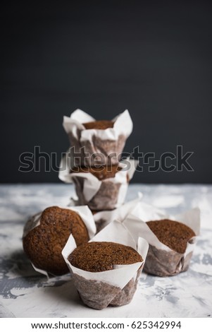 Chocolate muffins on the rustic background. Selective focus.