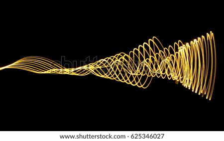 Gold Light Painting Photography, waves of colour against a black background