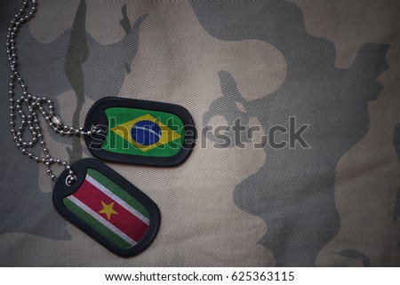 army blank, dog tag with flag of brazil and suriname on the khaki texture background. military concept