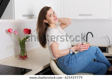Pretty young woman eating breakfast at her kitchen