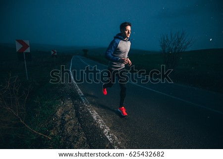 Man running outside in nature at rainy evening
