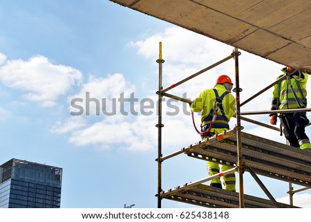 Construction workers on a scaffold. Royalty-Free Stock Photo #625438148
