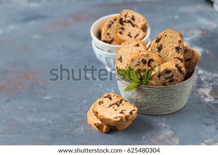 Italian cantuccini in a ceramic bowl on a table, with a red checkered napkin