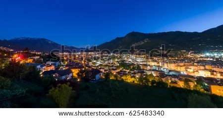Beautiful night skyline of city in mountain valley, panoramic view of Trento, Italy