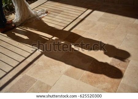 shadow of a bride and groom over stone floor