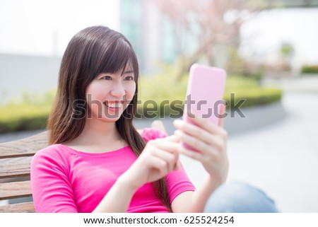 woman use phone ans smile happily in the park