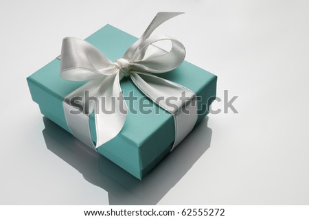 small turquoise box tied with a white ribbon Royalty-Free Stock Photo #62555272