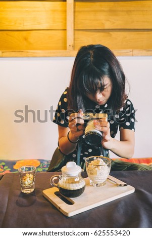 A cup of coffee with blurred girl in background.