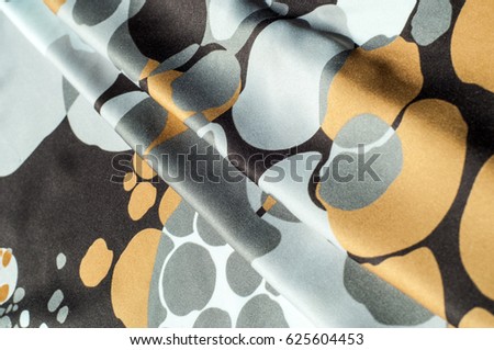 Texture, background, pattern. Abstract pattern on a silk fabric, white yellow brown circles