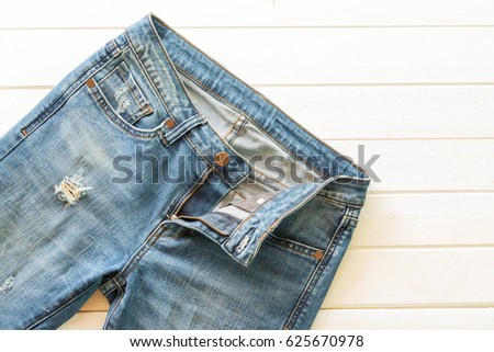 lacked blue jeans on white wood background