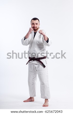 A young sporty man in a kimono. Jiu Jitsu, Judo. Coach, fighter, Wrestler. White isolated background