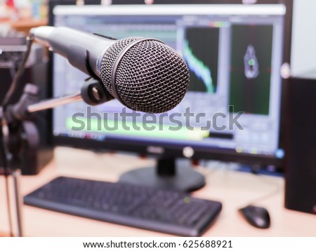 Microphone on the background of the computer monitor. Home recording Studio. Close-up. The focus in the foreground. Blurred background. Software for recording and editing sounds. Postproduction