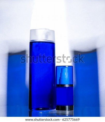 Cosmetics in blue bottles on a white background with shadow