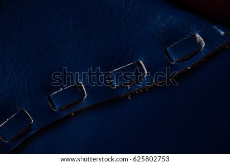 Blue leather with decor element, strip. Macro fragment of a leather bag or purse. Handmade, texture background.