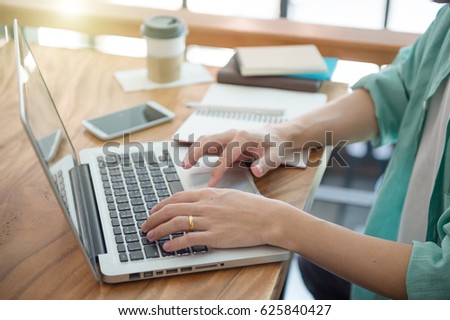 Business male hands typing on a laptop keyboard on desk with a cup of coffee in evening light,Urgent agenda,Freelance work at home office. 
