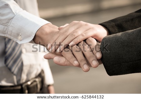 Image of businesspeople hands on top of each other as symbol of their partnership.Cropped image of young business team holding hands together.