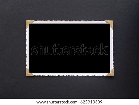 Photo frame - real old photo with black blank space for copy photo or text, pasted with gold color photo holder corners onto black vintage album paper page Royalty-Free Stock Photo #625913309