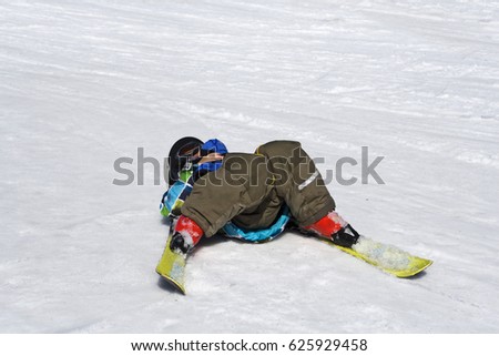The little skier lies on the snow