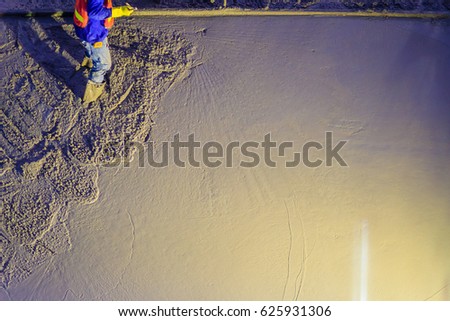 Mason worker leveling concrete with trowels, mason hands spreading poured concrete. Concreting workers are leveling poured liquid concrete on a steel reinforcement to form strong floor slab. Royalty-Free Stock Photo #625931306