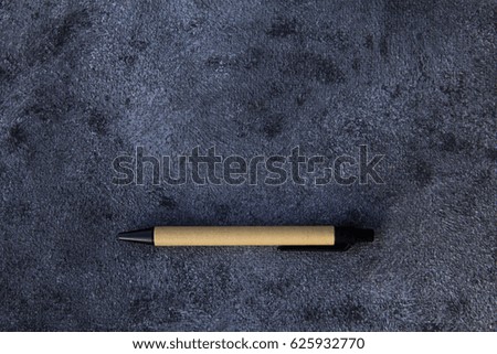 pen of recyclable materials lies on a dark background