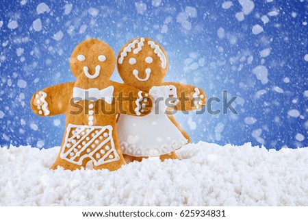 Gingerbread cookies, gingerbread men in the snow on blue background, Christmas or New Year background, template greeting card