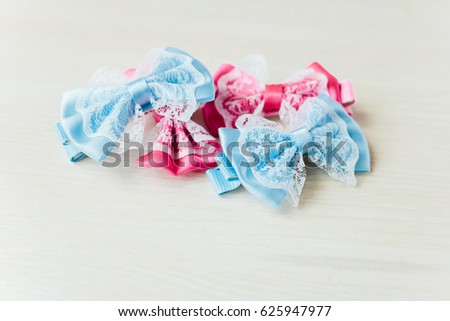 Barrette bow. Hairpin Butterfly. Blue and pink hair accessories. White wooden background
