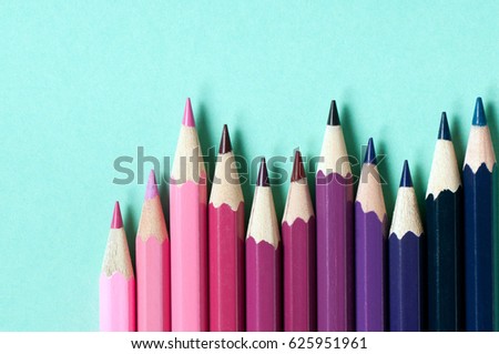 Color pencils isolated on turquoise background.