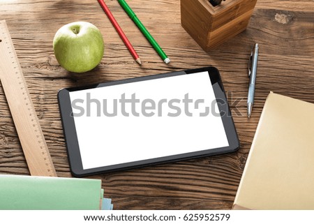Green Apple And Blank Screen Digital Tablet On Wooden Table With Office Supplies