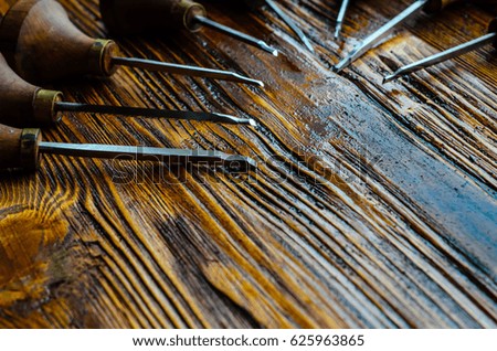 Different gravers for jewelry on a wooden background