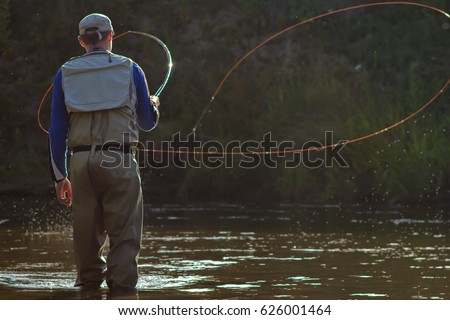 A fisherman fishing with fly fishing. Beautiful cord rings when casting Circle Castes, Voodoo Castes Royalty-Free Stock Photo #626001464
