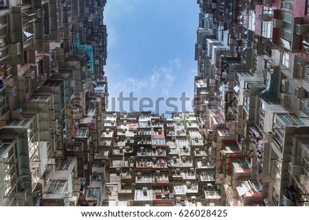 Crowded city apartment from bottom view against blue sky