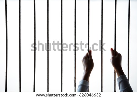 silhouette of hand in jail background.