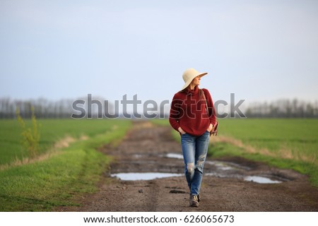 Young woman standing on a rural road, in the fields, space, sky, looking away, picture, nature, inspiration, walk
