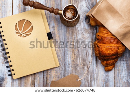 Morning coffee and fresh croissant on wooden table. Top view. Cozy breakfast. Flat lay style