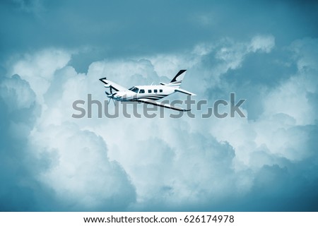 Single piston aircraft. Single-propeller aircraft flying over the blue sky. Single turboprop aircraft.. Small private plane flying in blue clouds. Royalty-Free Stock Photo #626174978