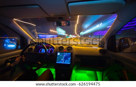The man drive a vehicle on the night road. Inside view. Wide angle