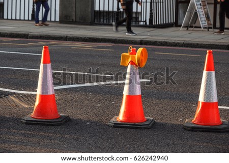 traffic cone, with white on gray asphalt, at roadwork