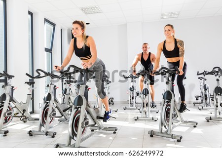 Group of fit people training at class. Cardio workout. Indoor cycling.